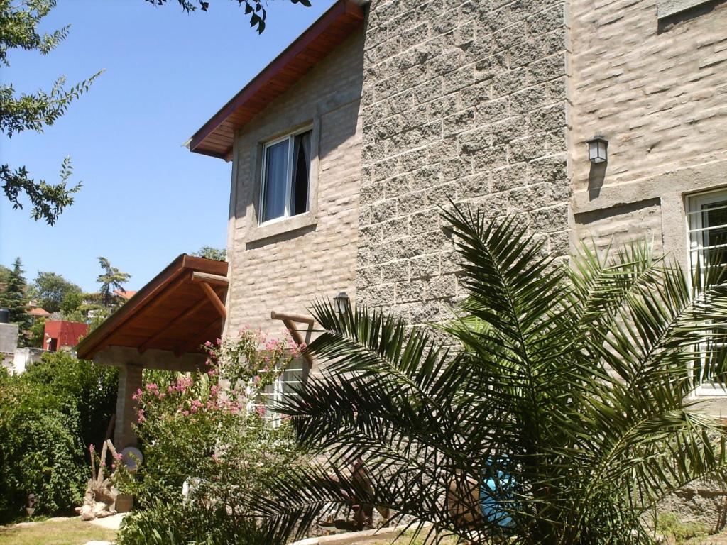 una casa de ladrillo con una palmera delante de ella en Villa Carlos Paz Alojamiento Santa Ponsa en Villa Carlos Paz