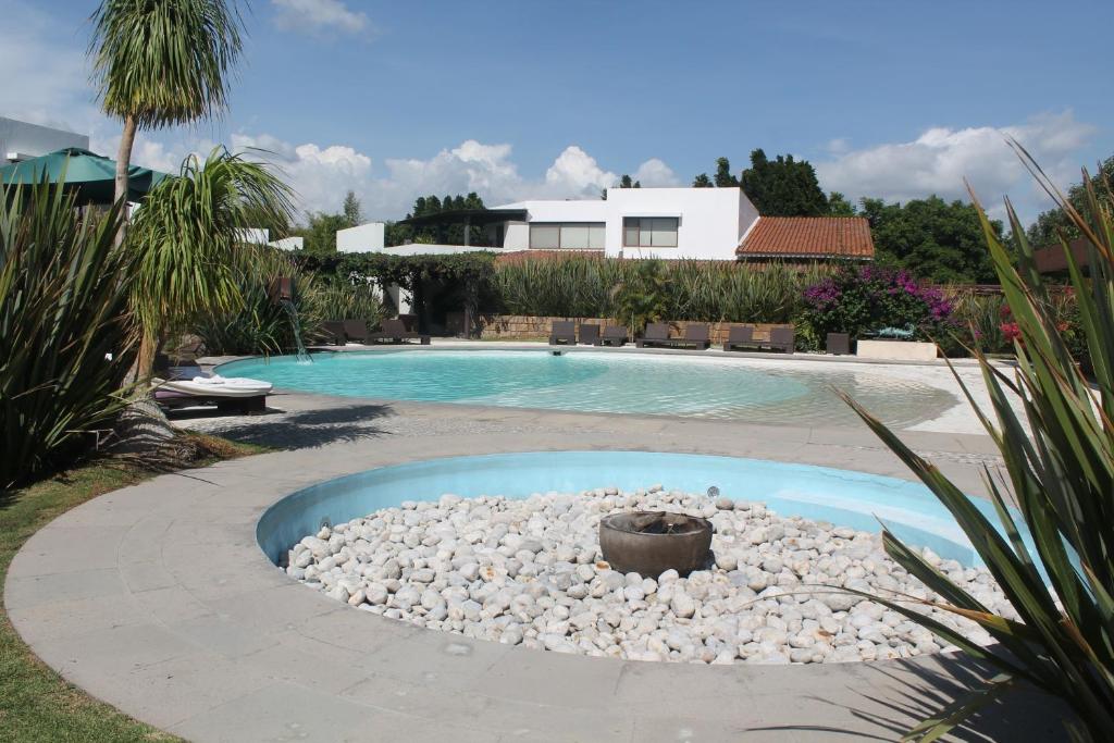 una piscina con un pozo de fuego en un patio en Hotel & Spa Luna Canela Boutique, en Atlixco
