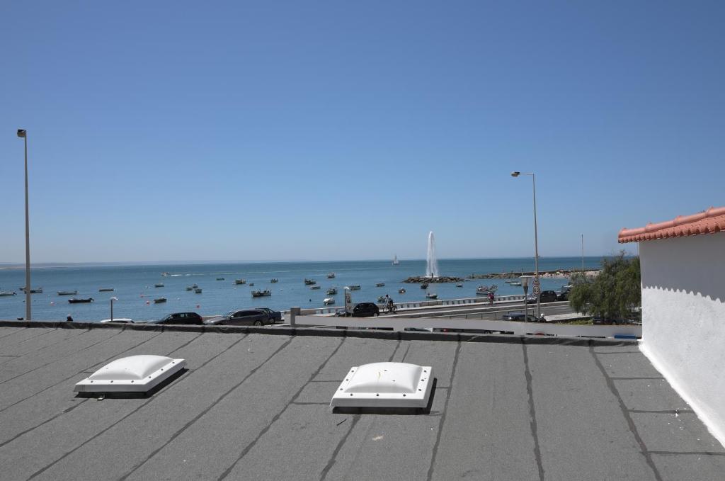 a view of a roof with boats in the water at Double Suite by the Ocean in Paço de Arcos