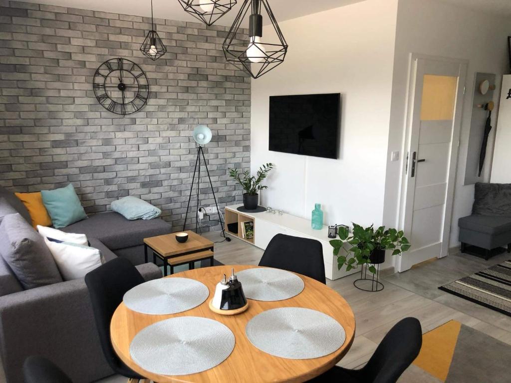 uma sala de estar com um sofá e uma mesa em Apartamenty Garden em Słupsk