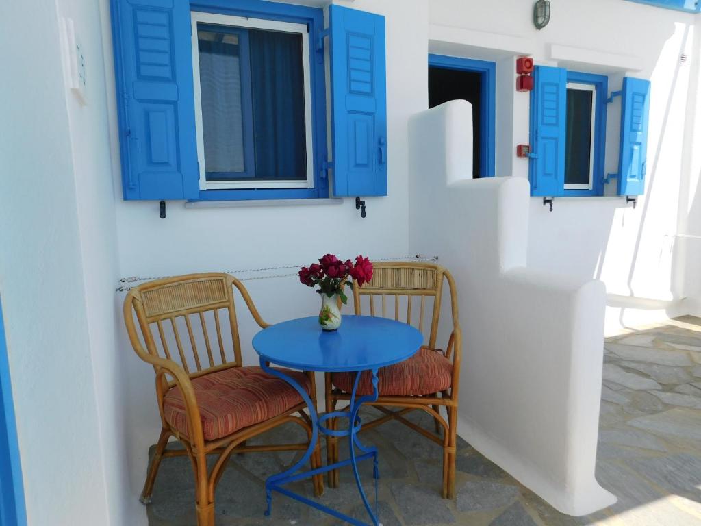 una mesa azul y 2 sillas con ventanas azules en Studio Elisabeth, en Agios Ioannis