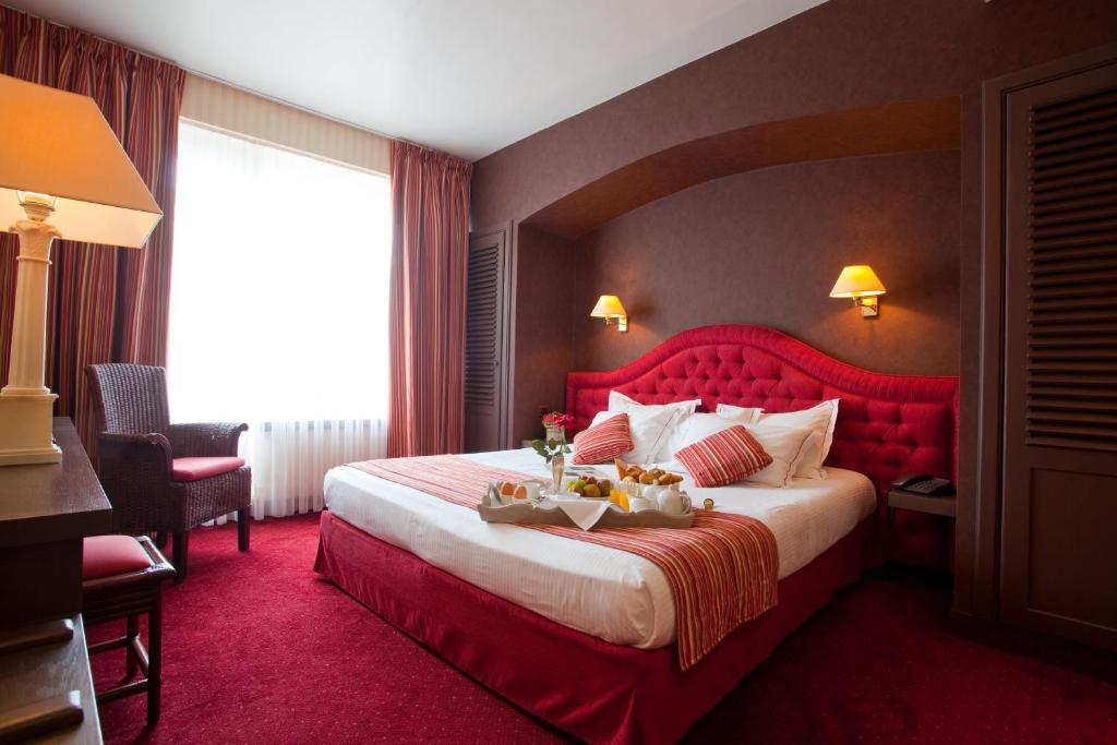 
a hotel room with a bed and a dresser at Hotel Imperial in Ostend
