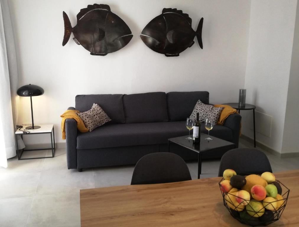 un soggiorno con divano e tavolo con cesto di frutta di Calamilloraptm2 a Cala Millor