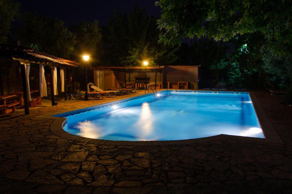 a swimming pool in a yard at night at Makis House in Nikiti