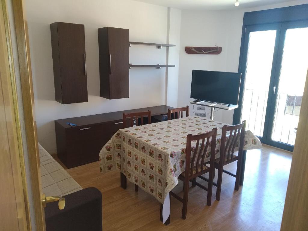 a room with a table and chairs and a television at Apartamento rural en bronchales, Sierra de Albarracín in Bronchales