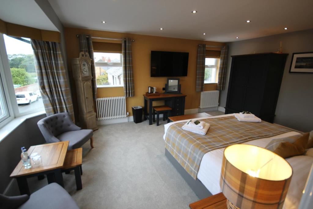 a hotel room with a bed and a desk at The Sunningdale in Bamburgh