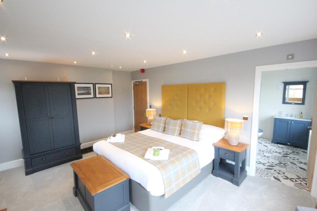 a bedroom with a large bed with a wooden headboard at The Sunningdale in Bamburgh