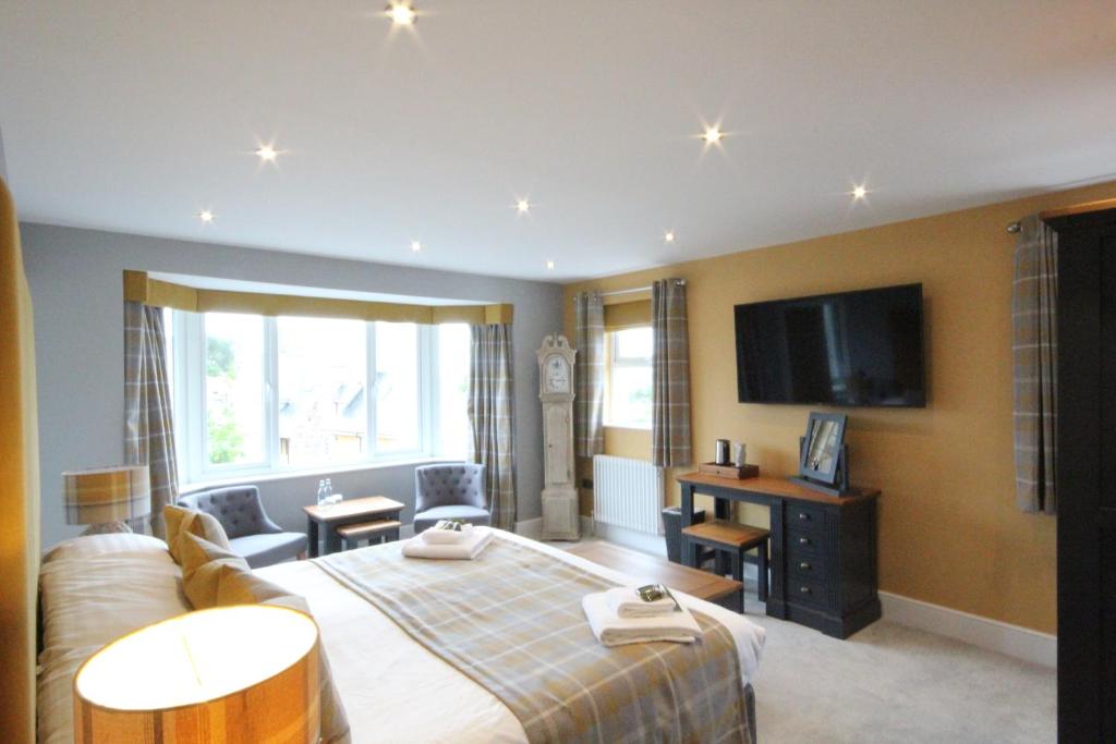 a hotel room with a bed and a flat screen tv at The Sunningdale in Bamburgh