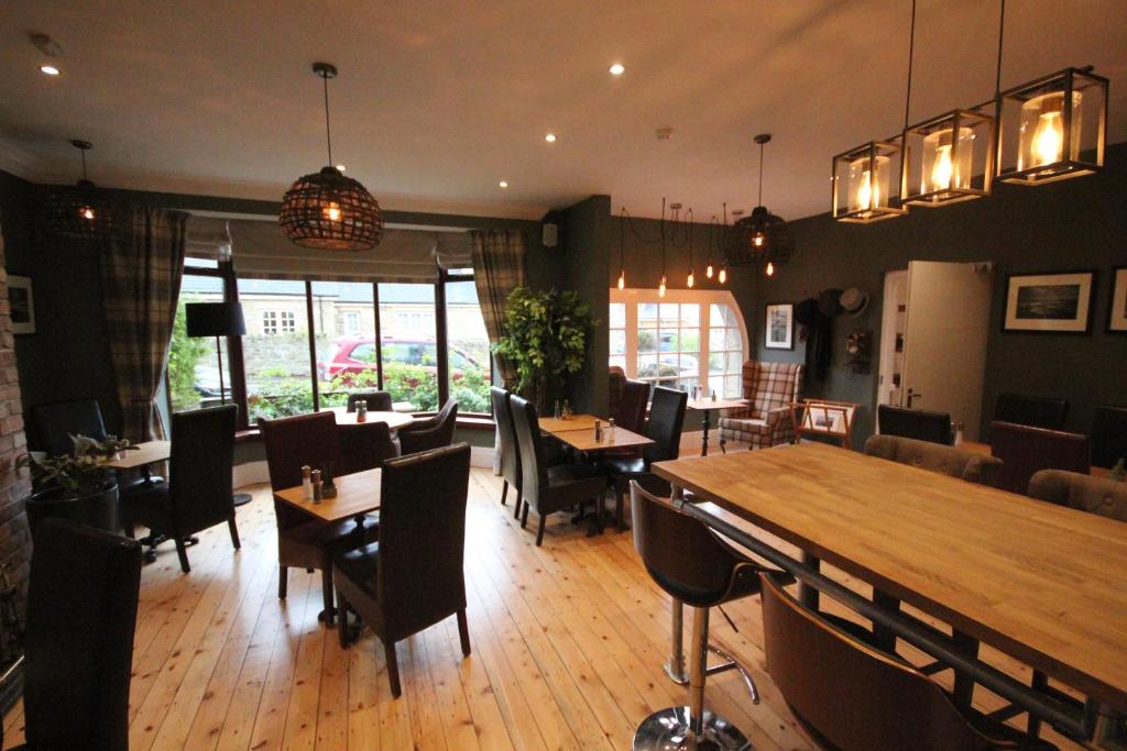 a restaurant with wooden floors and tables and chairs at The Sunningdale in Bamburgh