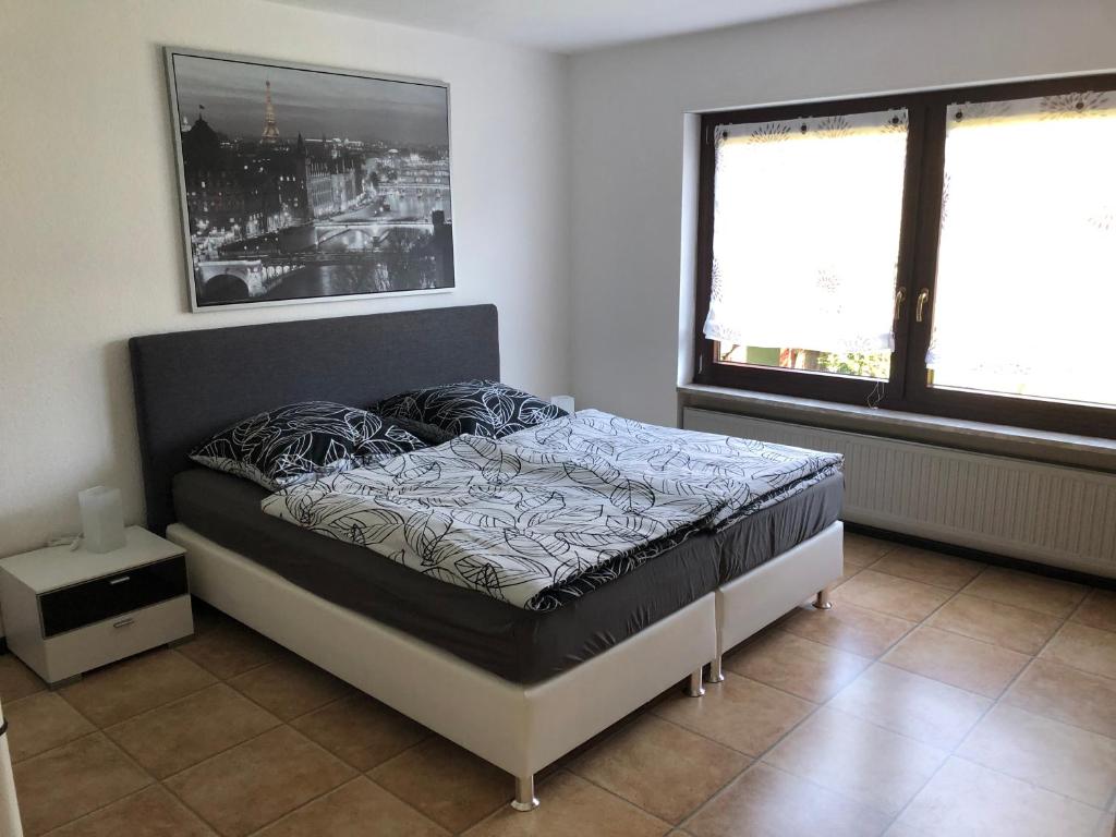 1 dormitorio con 1 cama en una habitación con 2 ventanas en Ferienwohnung Janson-2 en Wiesenbach
