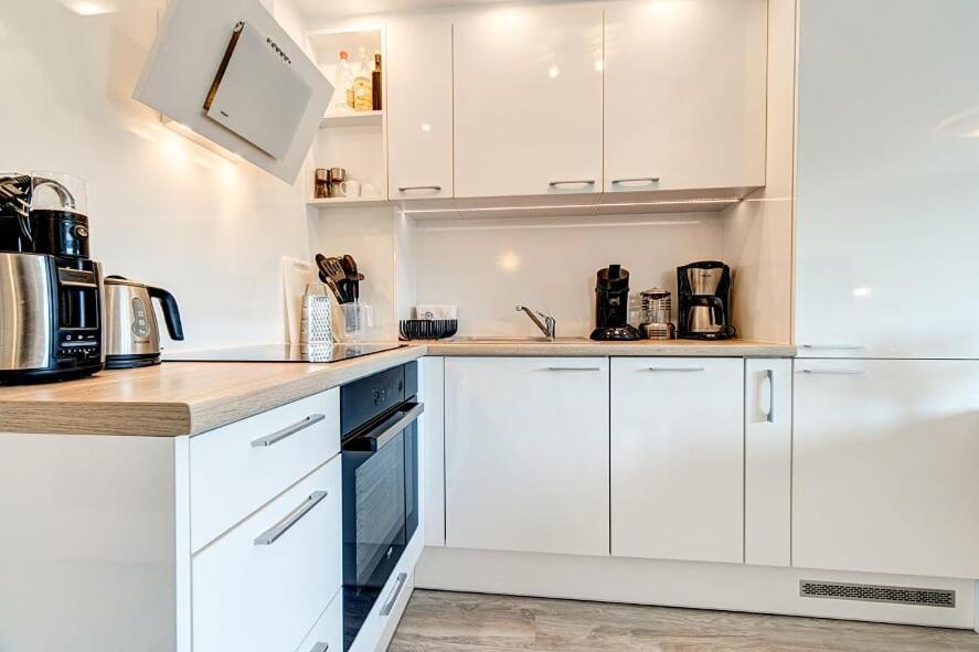 - une cuisine blanche avec des armoires et des appareils blancs dans l'établissement White Apartment Swinemünde, à Świnoujście