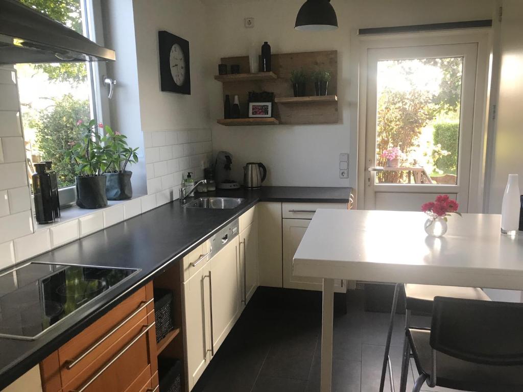 uma cozinha com uma mesa e um balcão branco em Nirosa em Epse