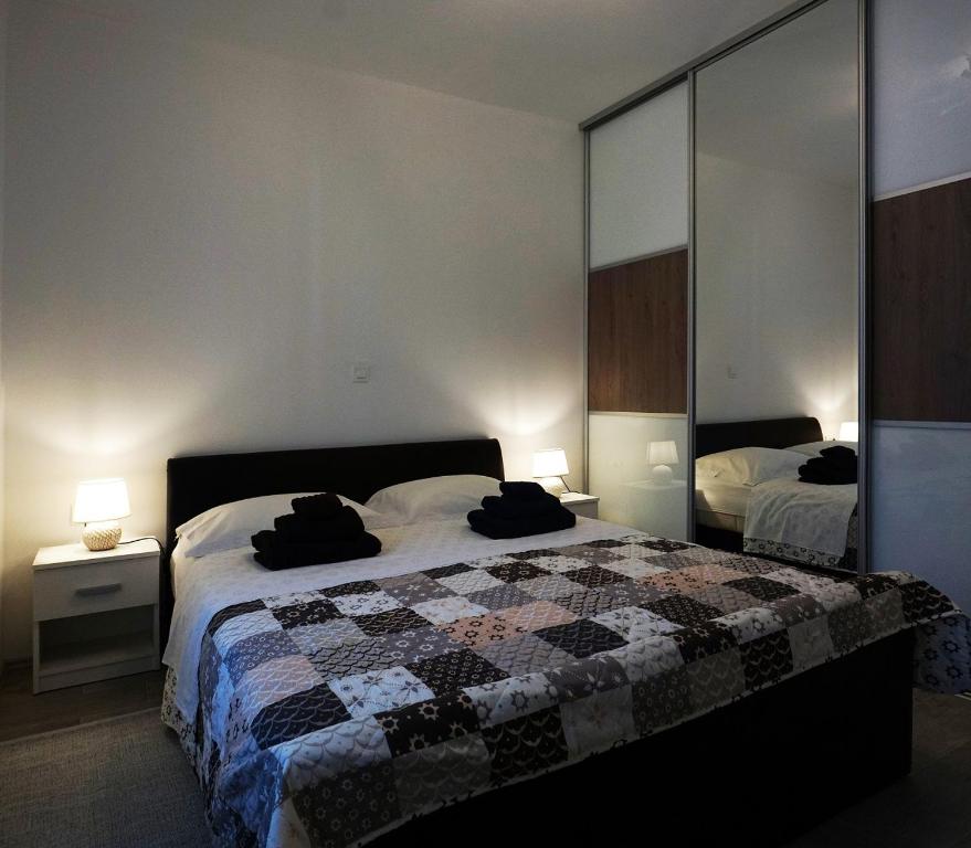 a bedroom with a bed and two lamps and a mirror at Deluxe Apartment Joia with Balcony on the Beach Bačvice, Free Parking, Old Town, Near Ferry Port in Split