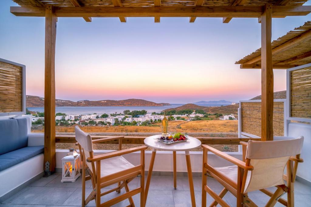 a patio with a table and chairs and a view of the ocean at Ammos Serifos in Serifos Chora