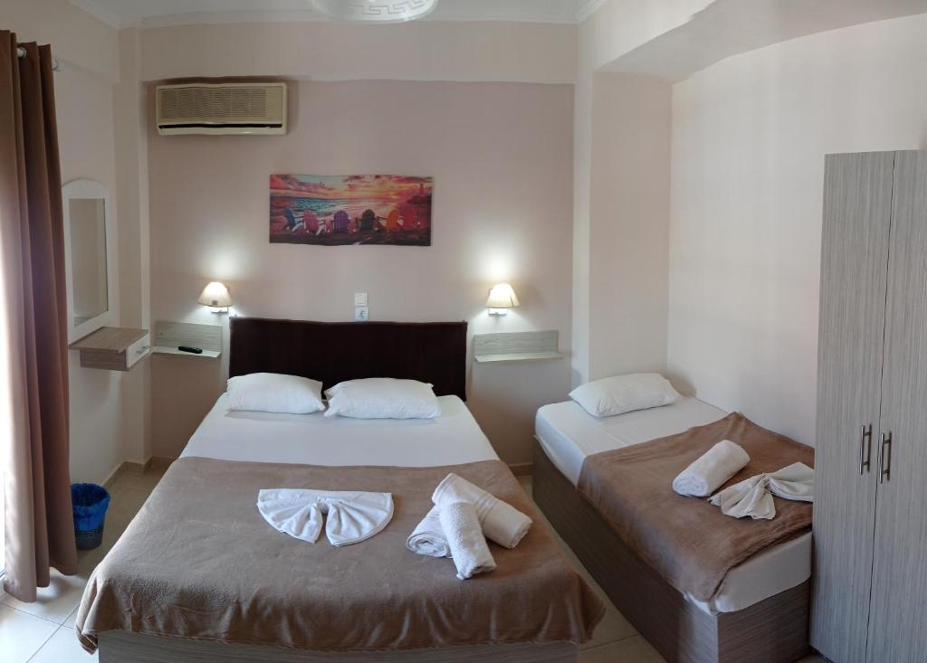 a hotel room with two beds with towels on them at Teo Rooms in Paralia Katerinis