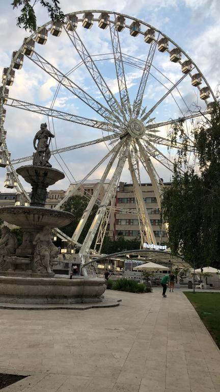 a large ferris wheel in front of a building at Corso Apartment in Budapest