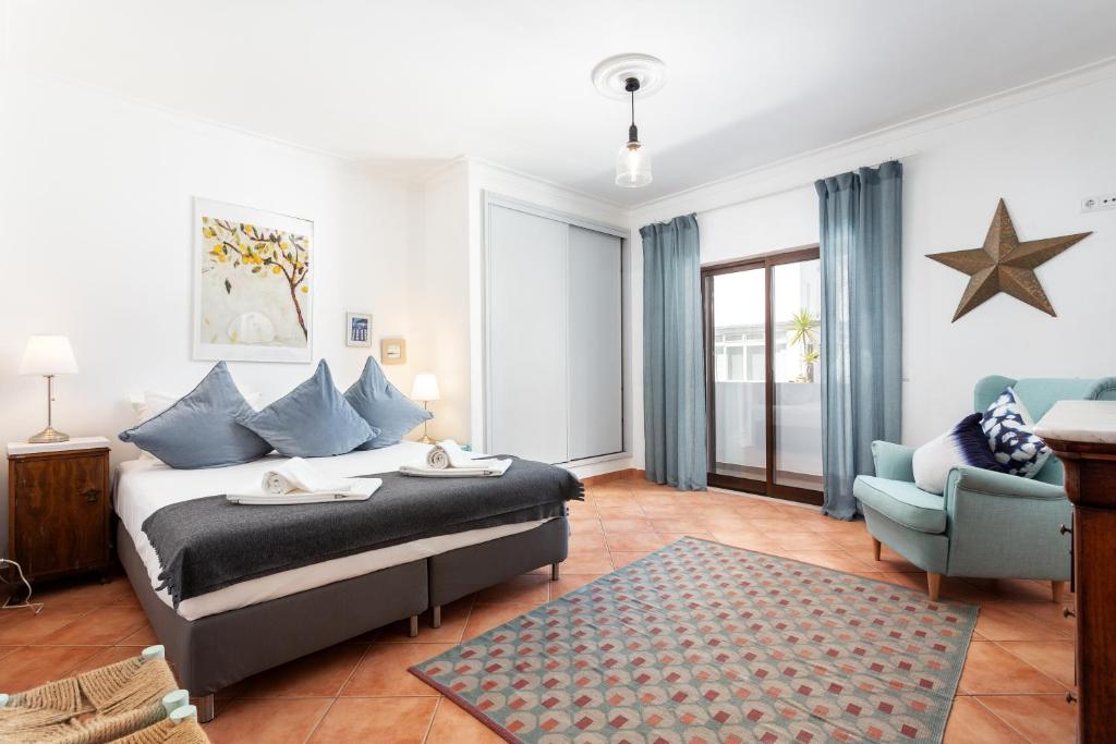um quarto com uma cama, um sofá e uma cadeira em Casa Lagosta em Olhão