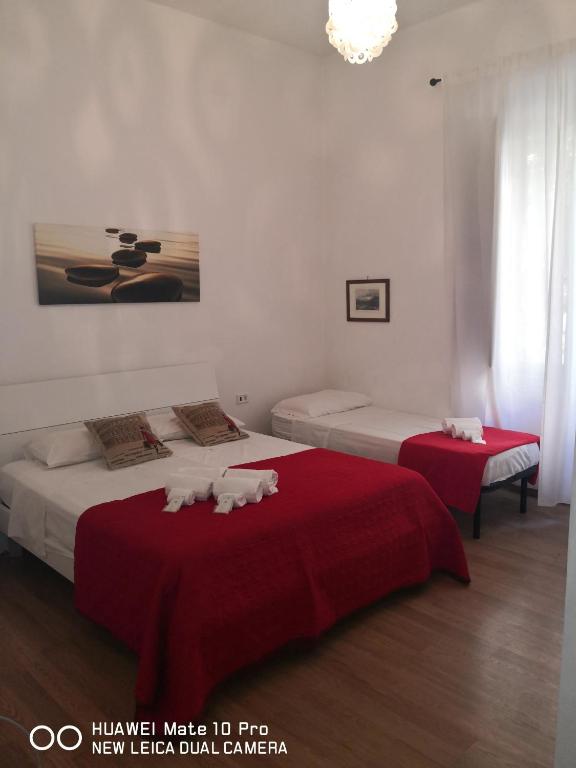 sypialnia z 2 łóżkami z czerwoną pościelą w obiekcie Trastevere four seasons Glorioso w Rzymie