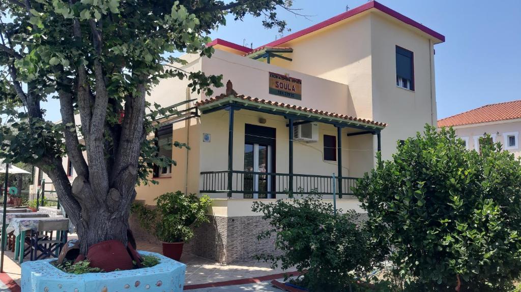 a building with a tree in front of it at Pension Soula in Skopelos Town