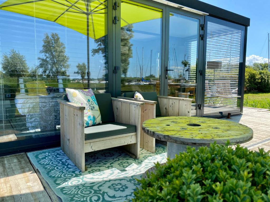 un patio con mesa, banco y sombrilla en Rent to ENJOY, en Warns