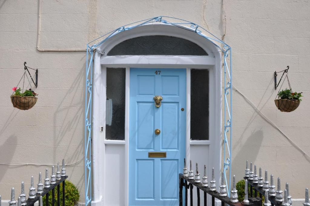 a blue door on a house with two baskets at Mulgrave Lodge in Dun Laoghaire