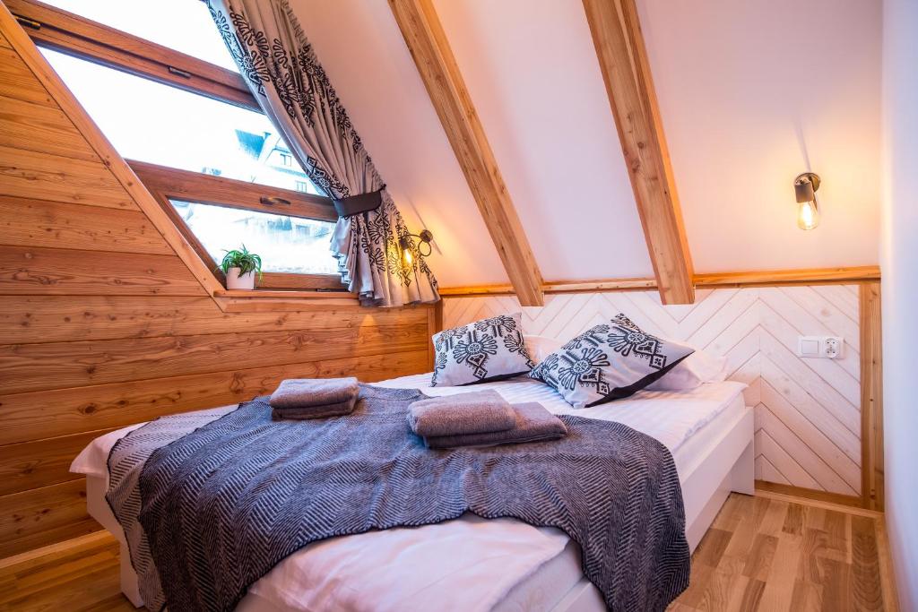 a bedroom with a bed in a room with wooden walls at Domek & Apartament Na Ogrodzie in Suche