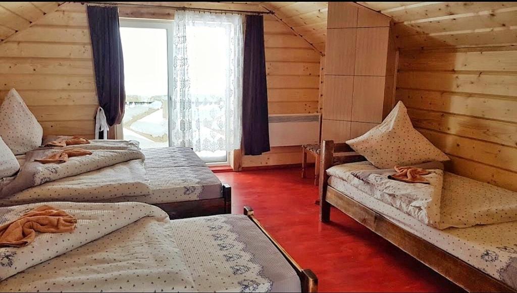 Habitación con 4 camas y ventana en У-Роберта en Dragobrat