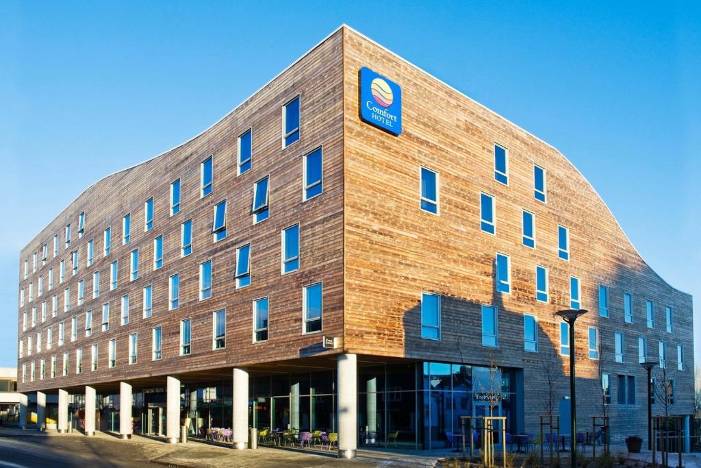 un gran edificio de ladrillo con un cartel azul en Comfort Hotel Square en Stavanger