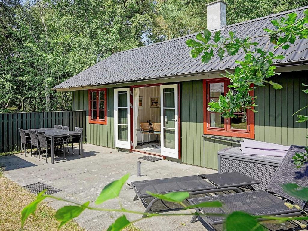 a green and red house with a table and chairs at 6 person holiday home in Nex in Snogebæk