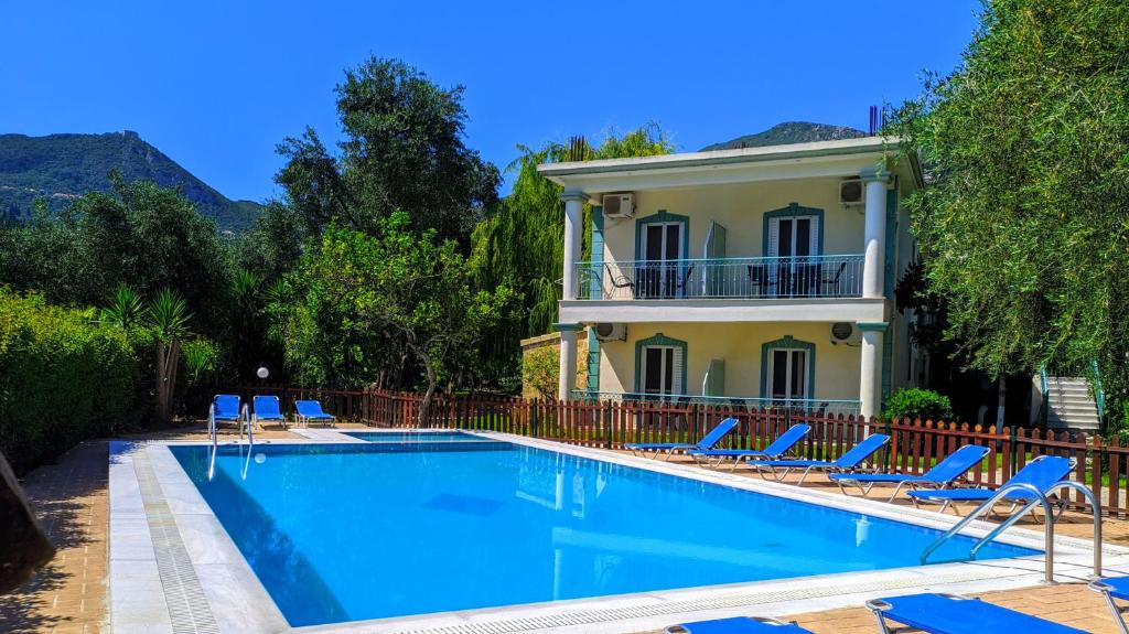 una piscina con sillas y una casa en Harmony Garden, en Parga