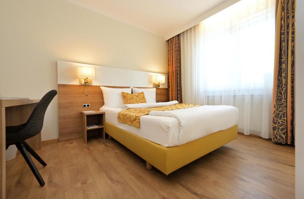 Un pat sau paturi într-o cameră la Hotel & Living Am Wartturm - Hotel & Apartments