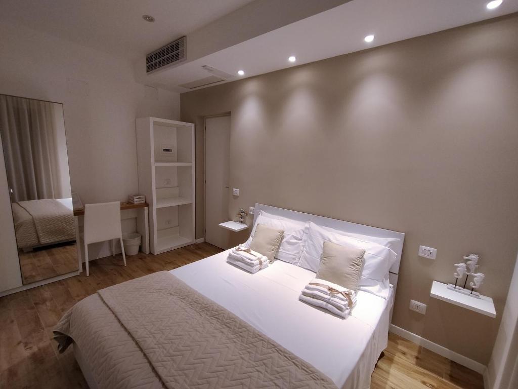 - une chambre avec un lit doté de draps et d'oreillers blancs dans l'établissement Seabed superior rooms, à Termoli