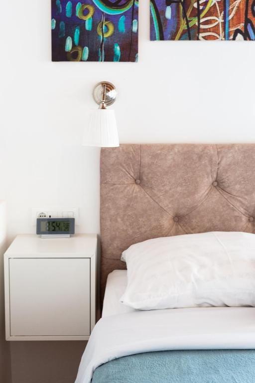 1 dormitorio con 1 cama y reloj en una mesita de noche en Orsan Residence, en Dubrovnik
