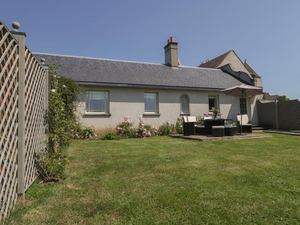 a house with a fence in front of a yard at Mappowder Cottage in Sturminster Newton