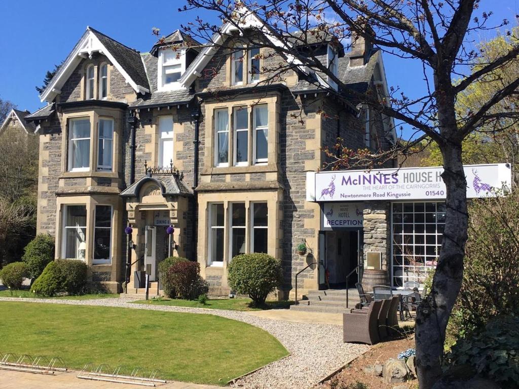 a large house with a sign in front of it at McInnes House Hotel in Kingussie