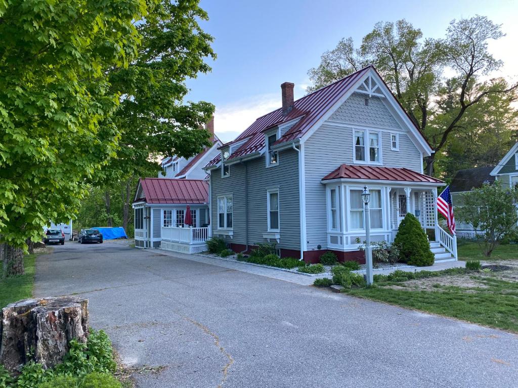 a white house with a red roof on a street at James Place Inn Bed and Breakfast in Freeport