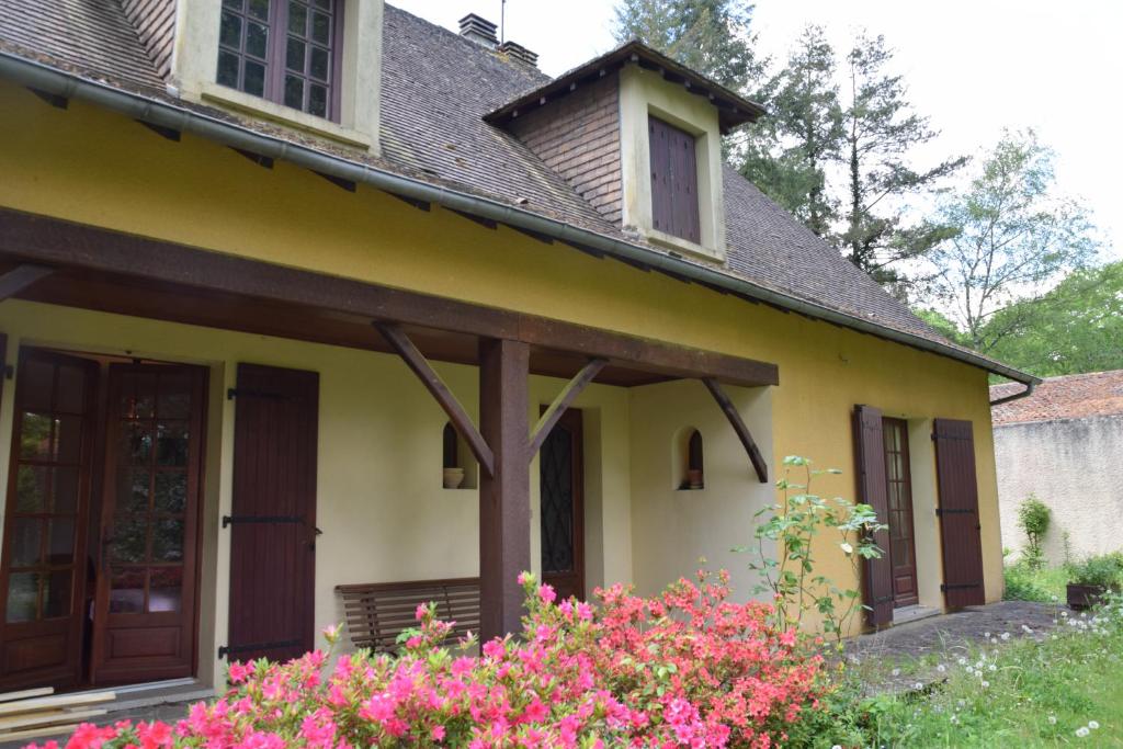 a yellow house with pink flowers in front of it at 'Les Comètes' B&B in La Caujonnet