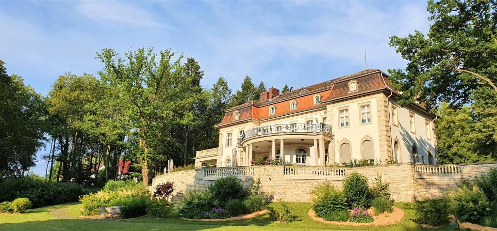 a large house with a fence in a yard at Hotel Villa Altenburg in Pößneck