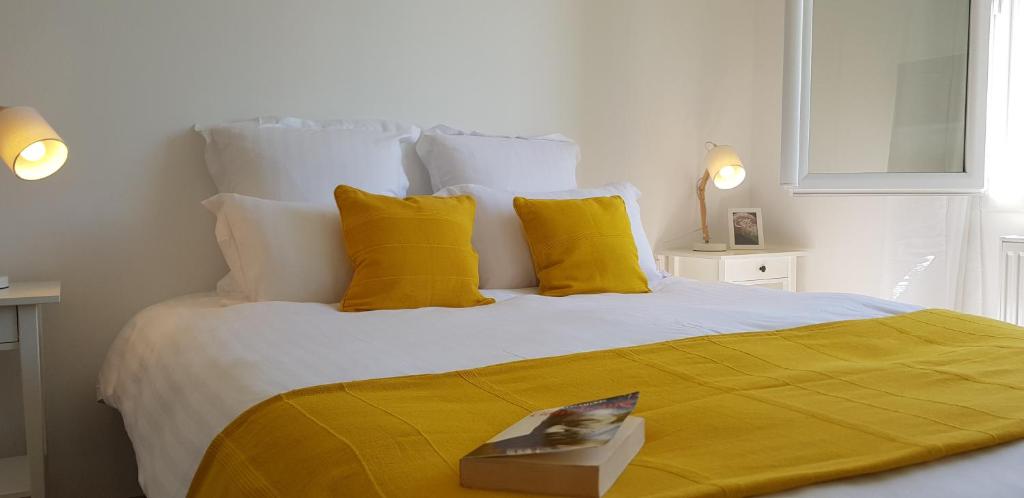 a bedroom with a large bed with yellow pillows at Chambres d'hôtes Gite Grange Debout in Beynost