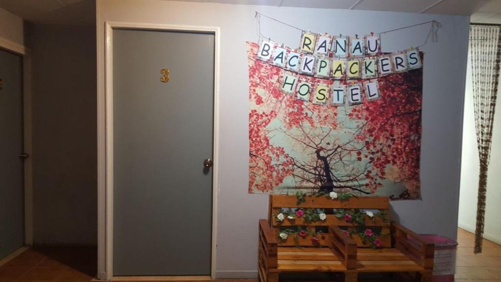 une chambre avec un tableau sur le mur et un banc dans l'établissement Ranau Backpackers Hostel, à Ranau
