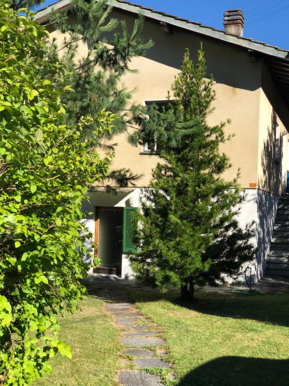 a house with two pine trees in front of it at Casa Silvia in Gordevio