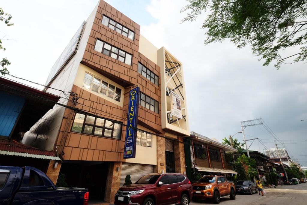 un edificio con coches estacionados frente a él en Oriental Zen Suites, en Manila