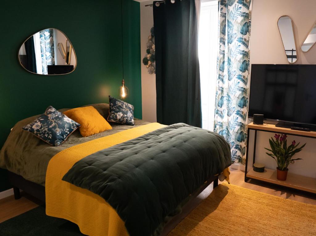 a bedroom with a bed and a mirror and a television at studio coeur de ville neuf et design tt equipé parking gratuit in Sanary-sur-Mer