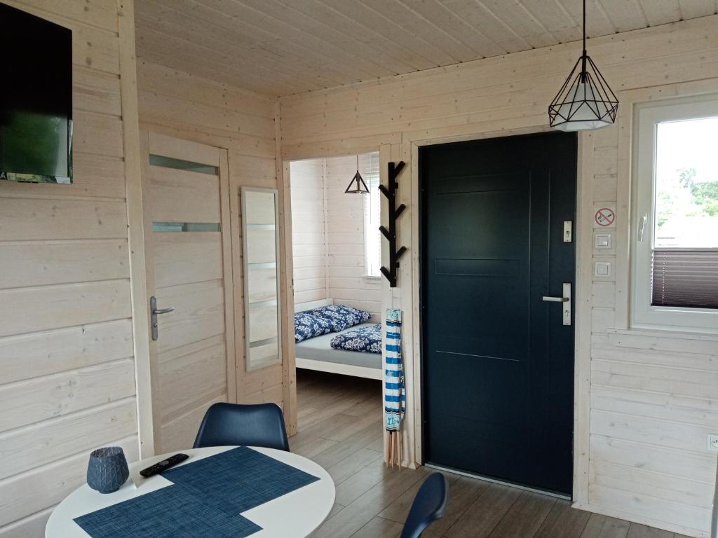 a room with a black door and a bed at Domki na górce in Kołczewo