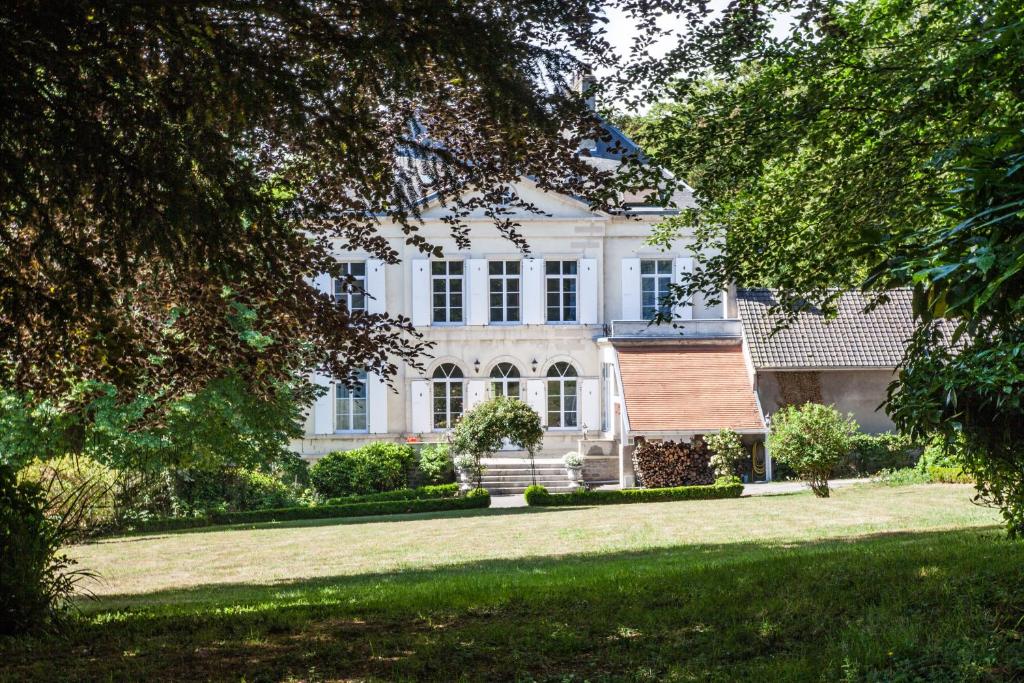 ein großes weißes Haus mit Rasen davor in der Unterkunft Maison Grandsire Chambres D'Hôtes in Saint-Léonard