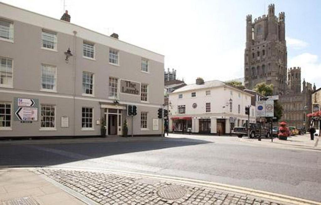 an empty street in a city with a large building at Lamb Hotel by Greene King Inns in Ely