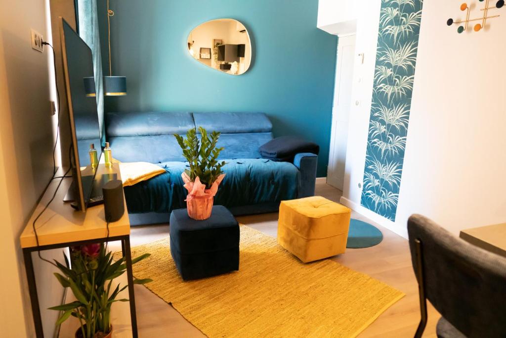 - un salon avec un canapé bleu et une table dans l'établissement coeur de ville t2, terrasse, clim tt équipe, parking, à Sanary-sur-Mer