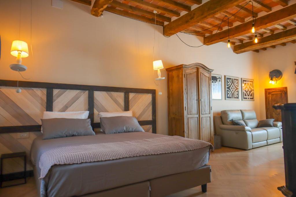 een slaapkamer met een bed en een bank in een kamer bij B&B La Taccola in Castelnuovo di Val di Cecina