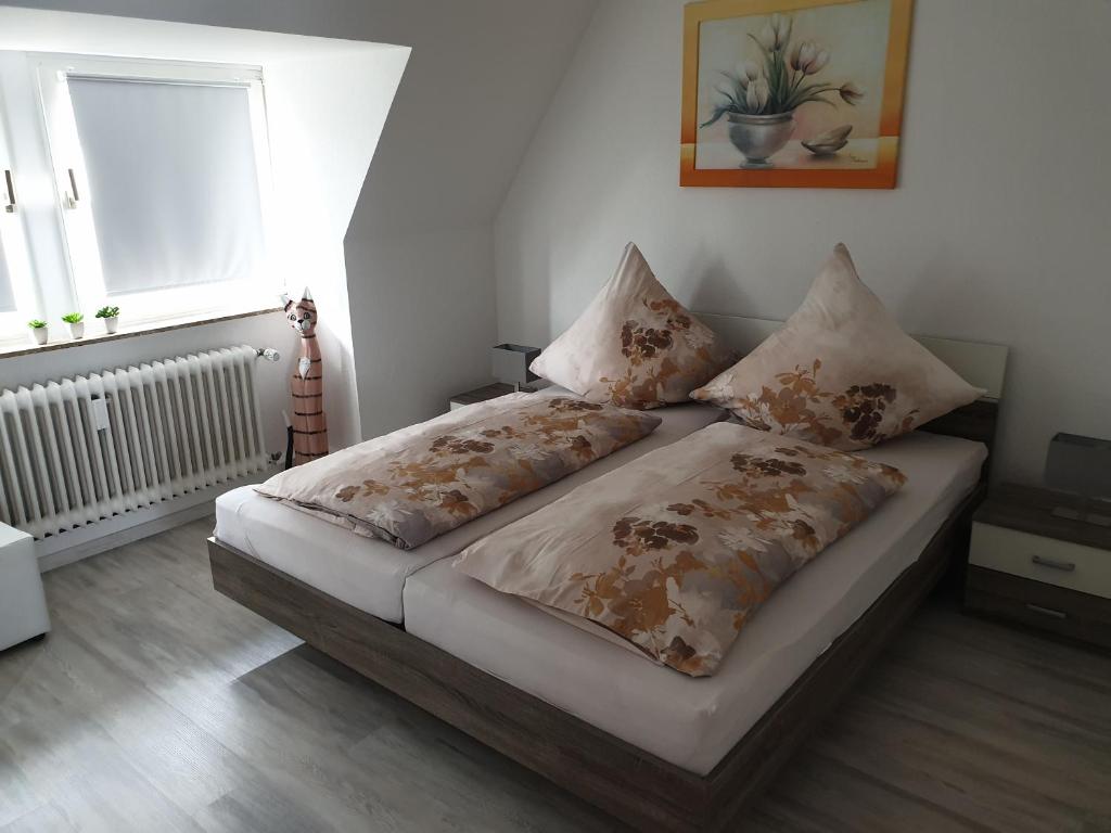 - une chambre avec un lit et 2 oreillers dans l'établissement Ferienwohnung Julia, à Emden