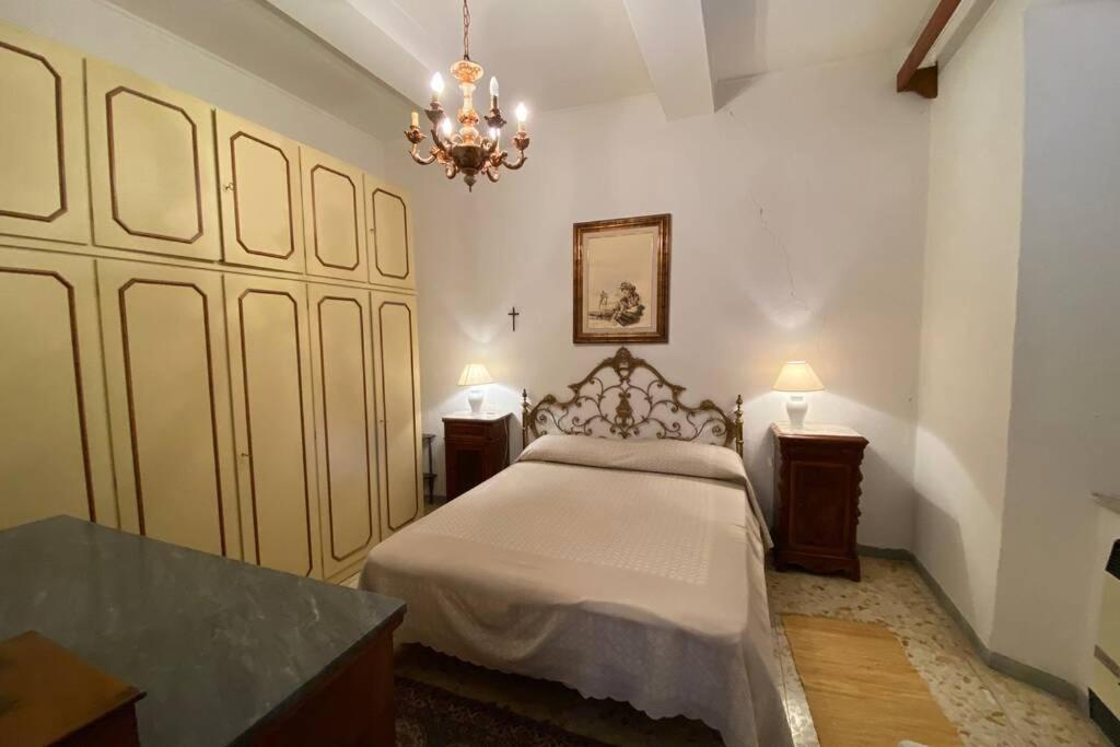 Un dormitorio con una cama y una lámpara de araña. en Casa Acquedotto Mediceo, en Pitigliano
